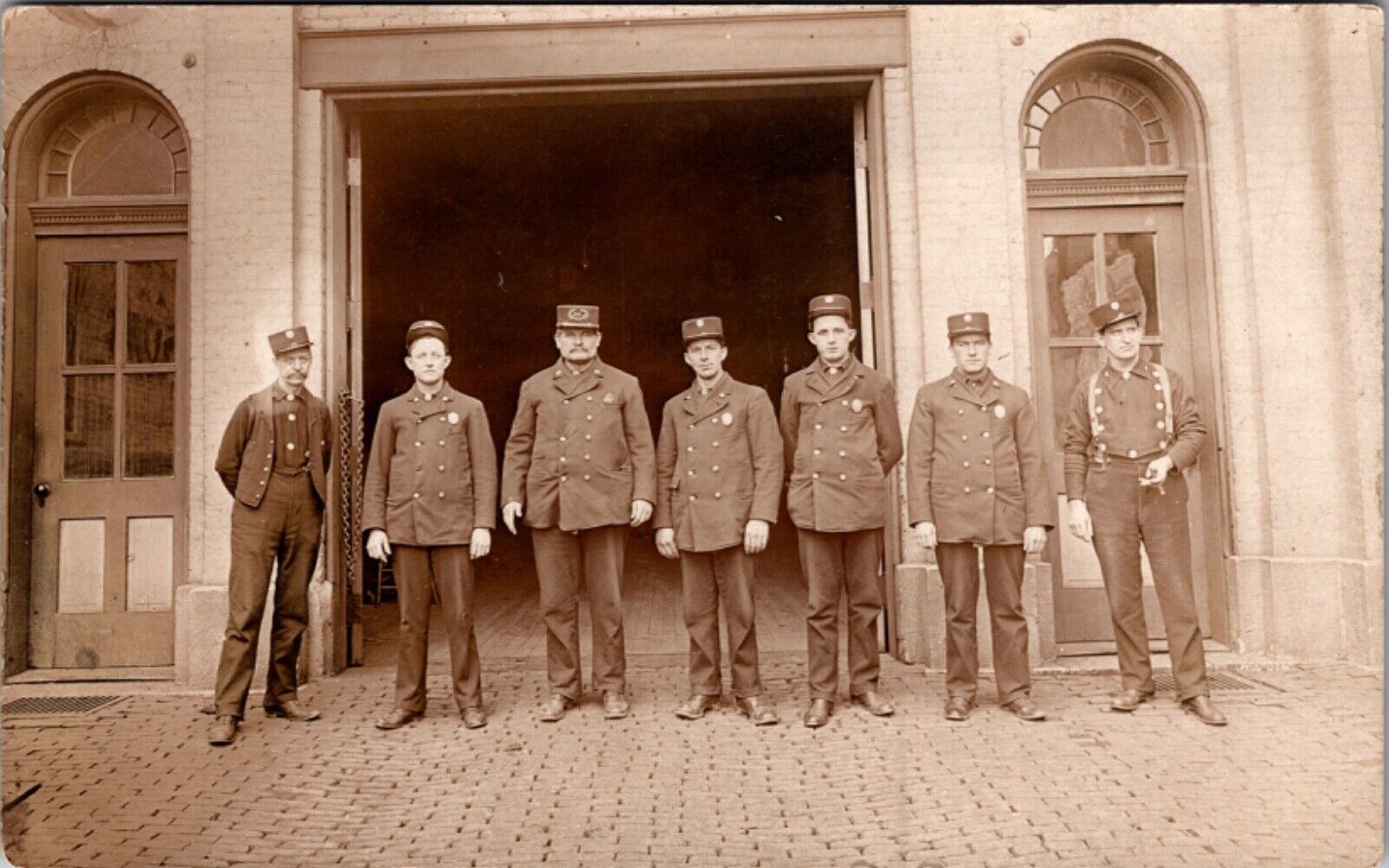 Real Photo Postcard Uniformed Firemen Standing Outside of Firehouse