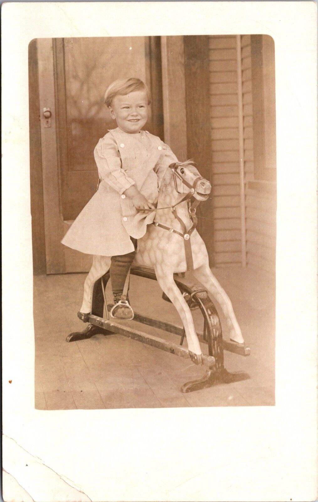 Real Photo Postcard Young Child Sitting on a Hobby Horse on a Front Porch