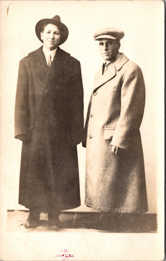 Real Photo Postcard Two Men Wearing Large Coats and Hats in a Photo Studio