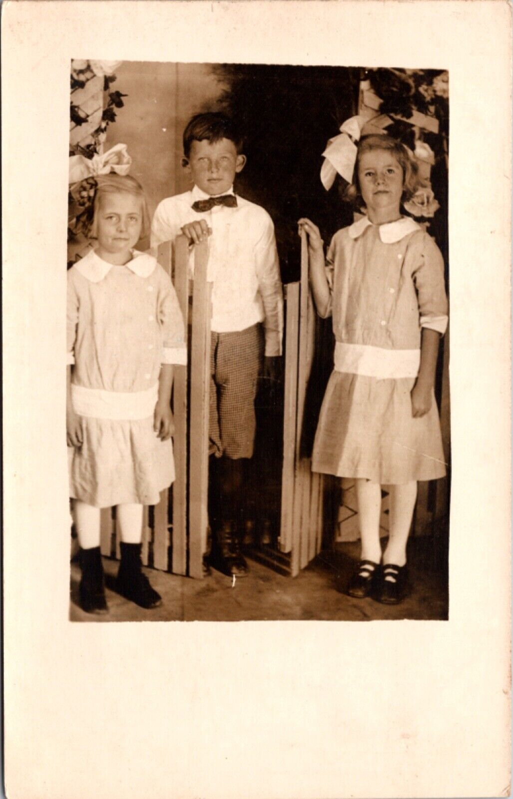 Real Photo Studio Postcard Two Young Girls and Boy Sibling Spring Picket Fence