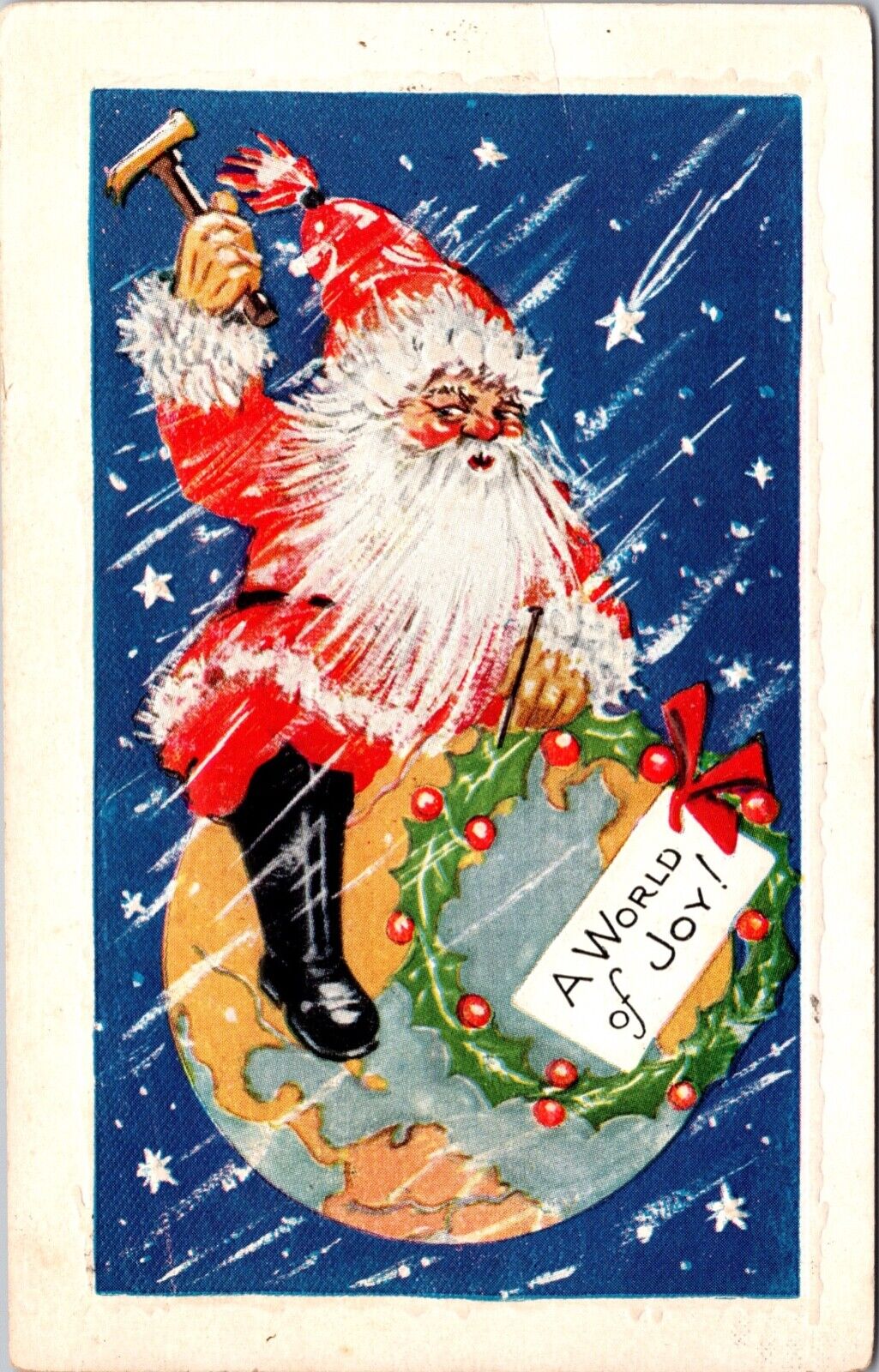 Christmas Postcard Santa Claus Sitting on and Nailing a Wreath To Planet Earth