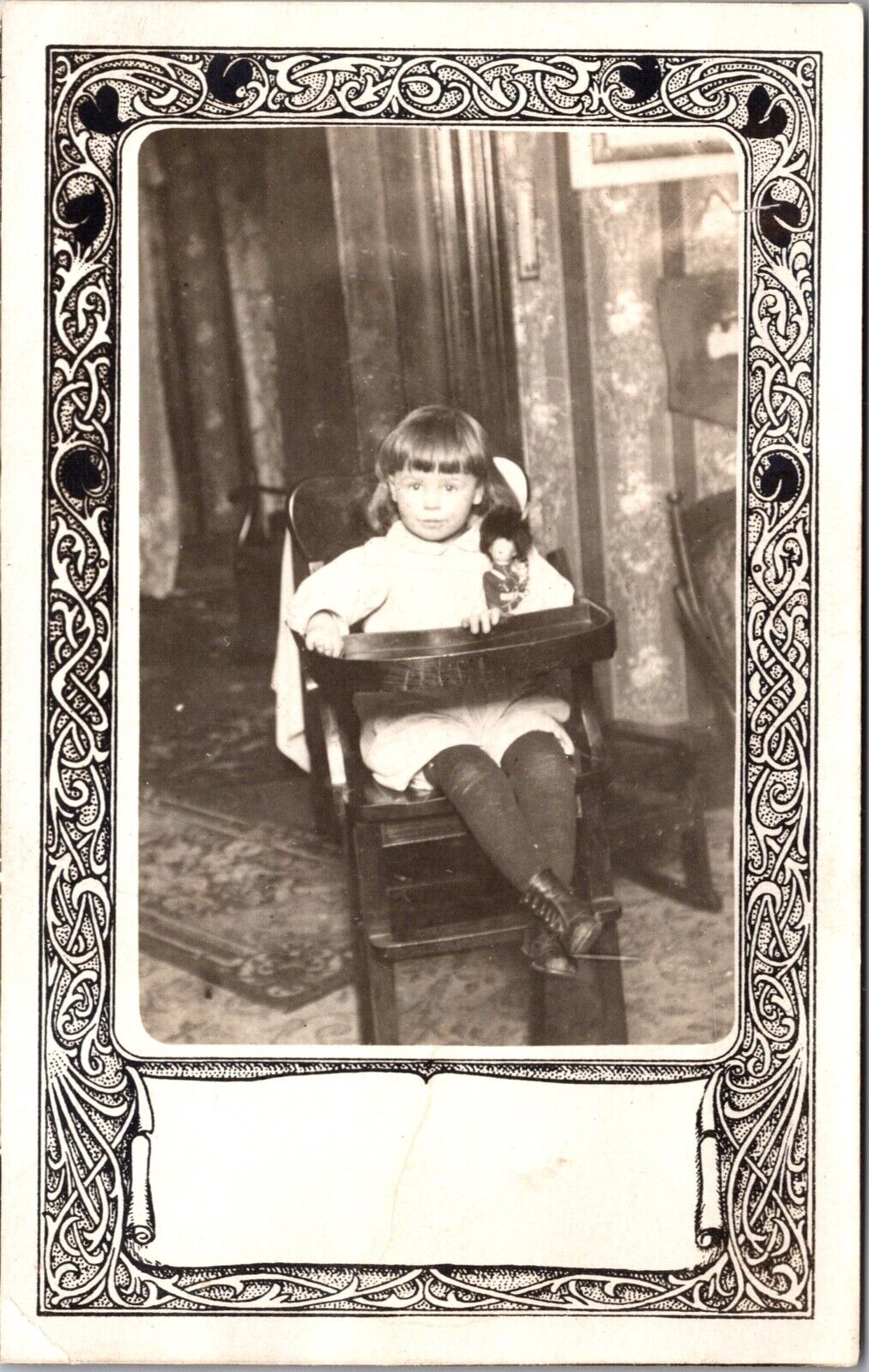 Real Photo Postcard Young Girl Sitting in a Wooden Highchair Holding a Doll