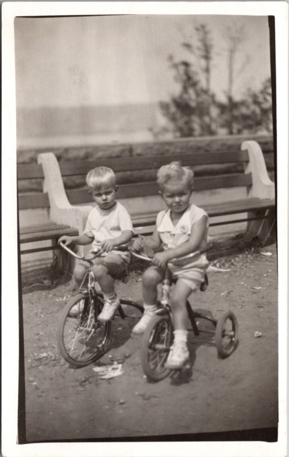 Real Photo Postcard Two Young Children Riding Tricycles in a Park